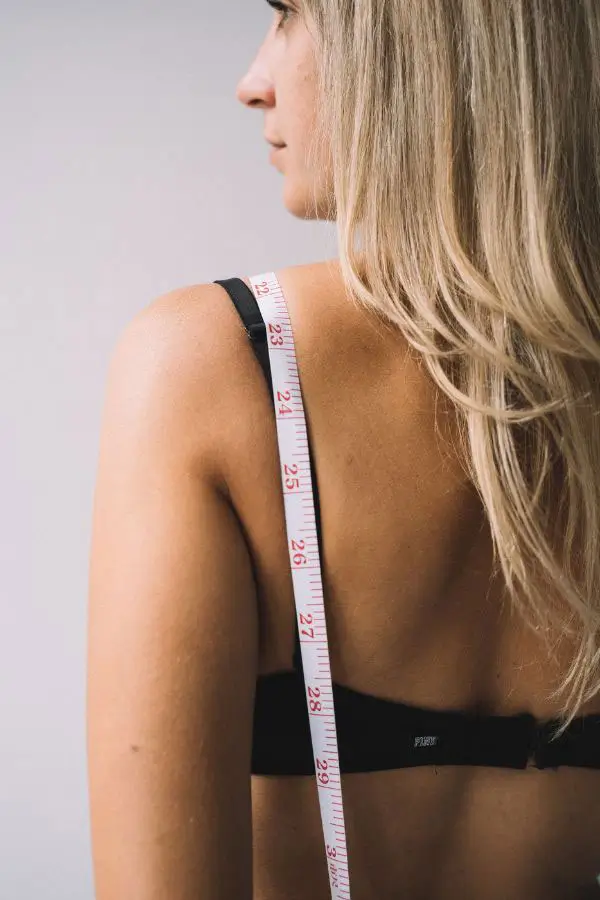 Woman with tape measure draped over her shoulder.