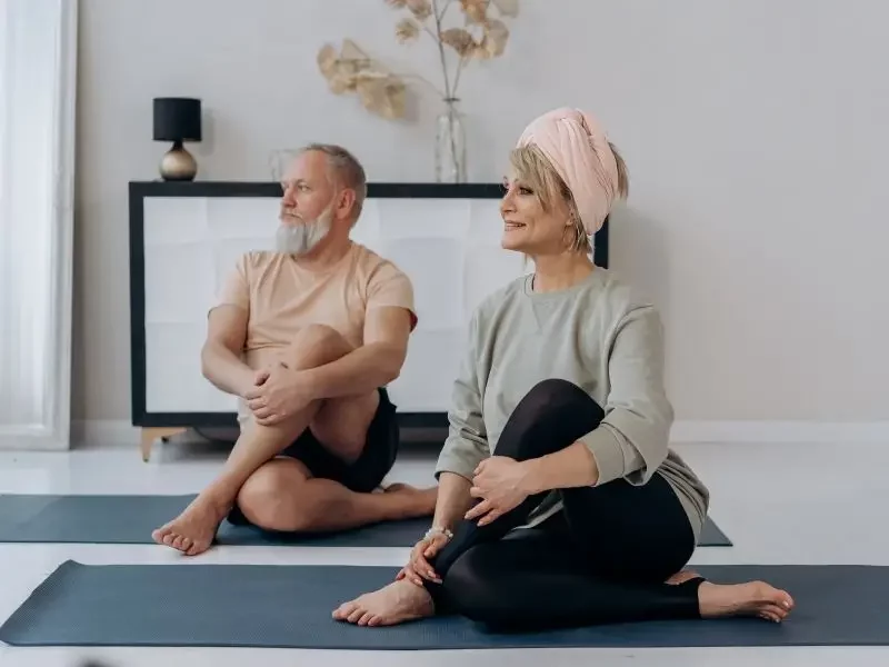 Mature couple doing yoga after feeling invigorated from bio-identical hormone therapy