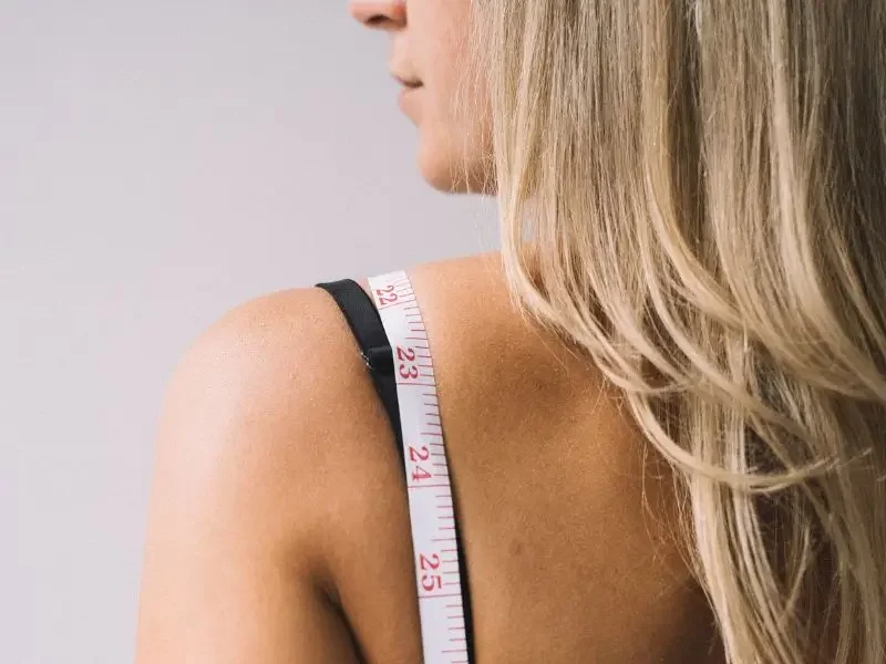 Woman with metabolic issues with a tape measure draped over her shoulder.