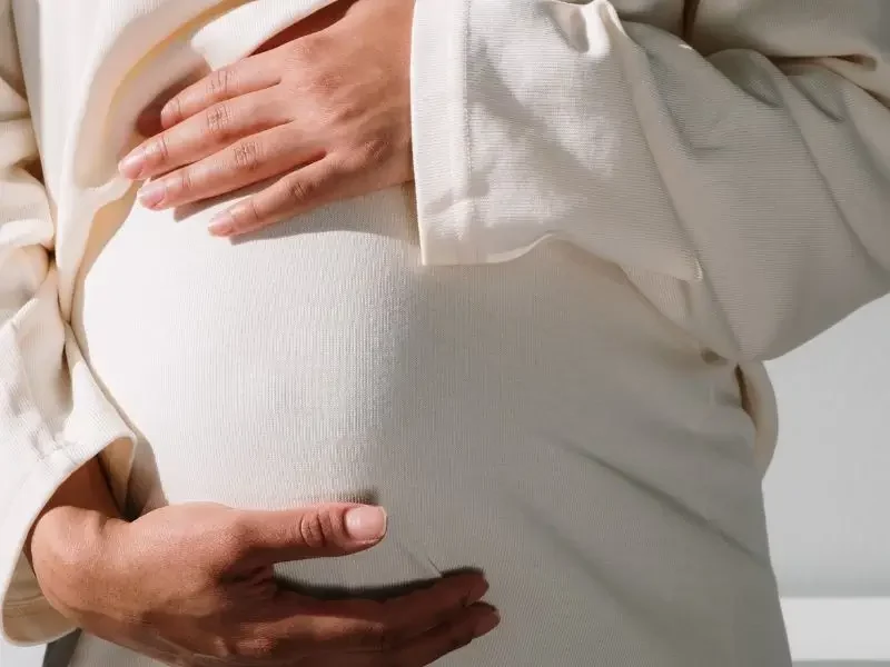 A pregnant woman holding her belly.